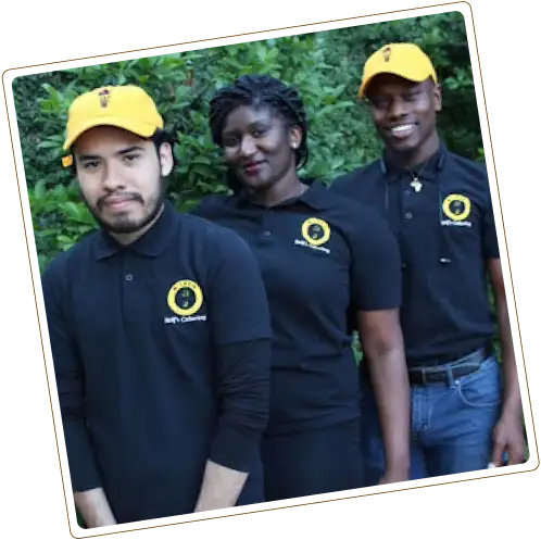 Three people outdoors in black polo shirts with yellow logos; two wear yellow caps.