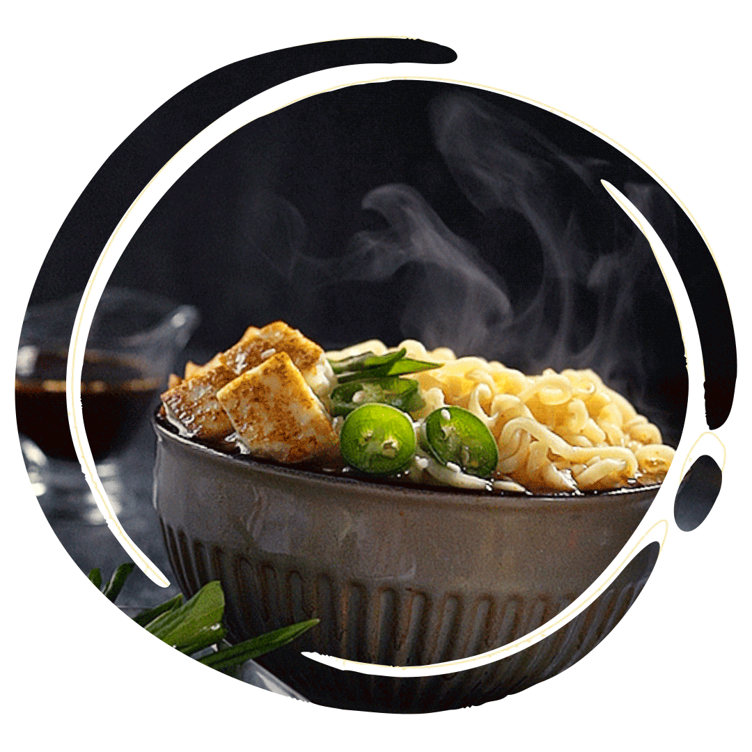 A steaming bowl of ramen noodles with tofu, green onions, and lime slices.